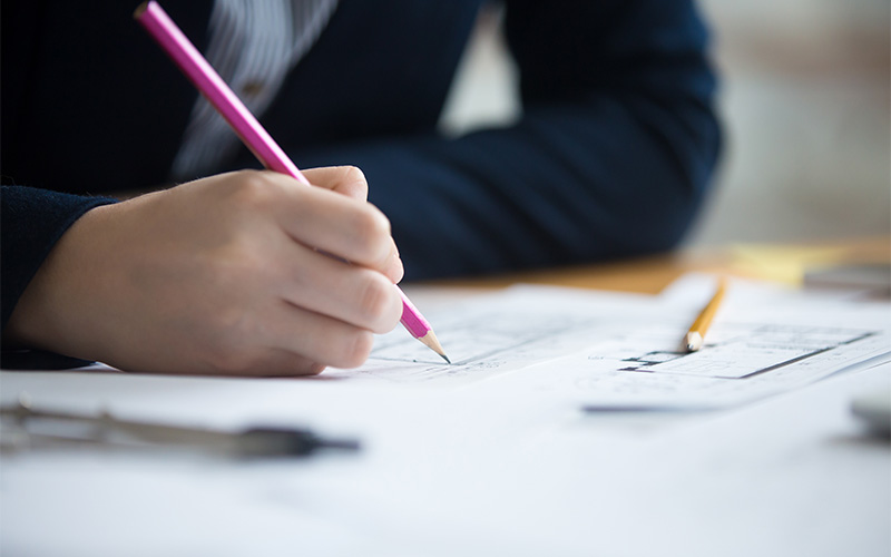 Student practicing English comprehension strategies by annotating a paper.