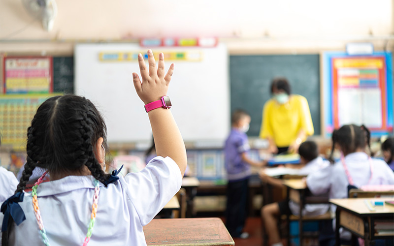 Student raising hand in Curion Education English enrichment class.
