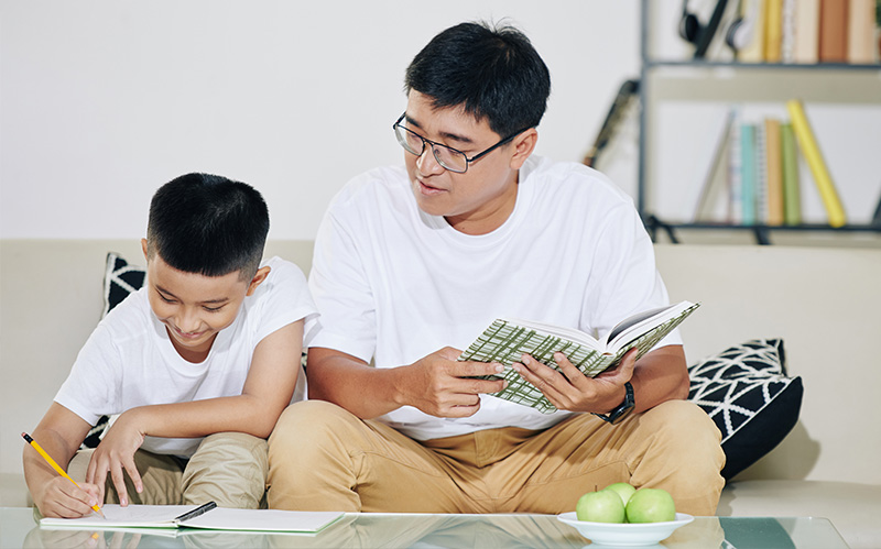 A father and son studying together at home